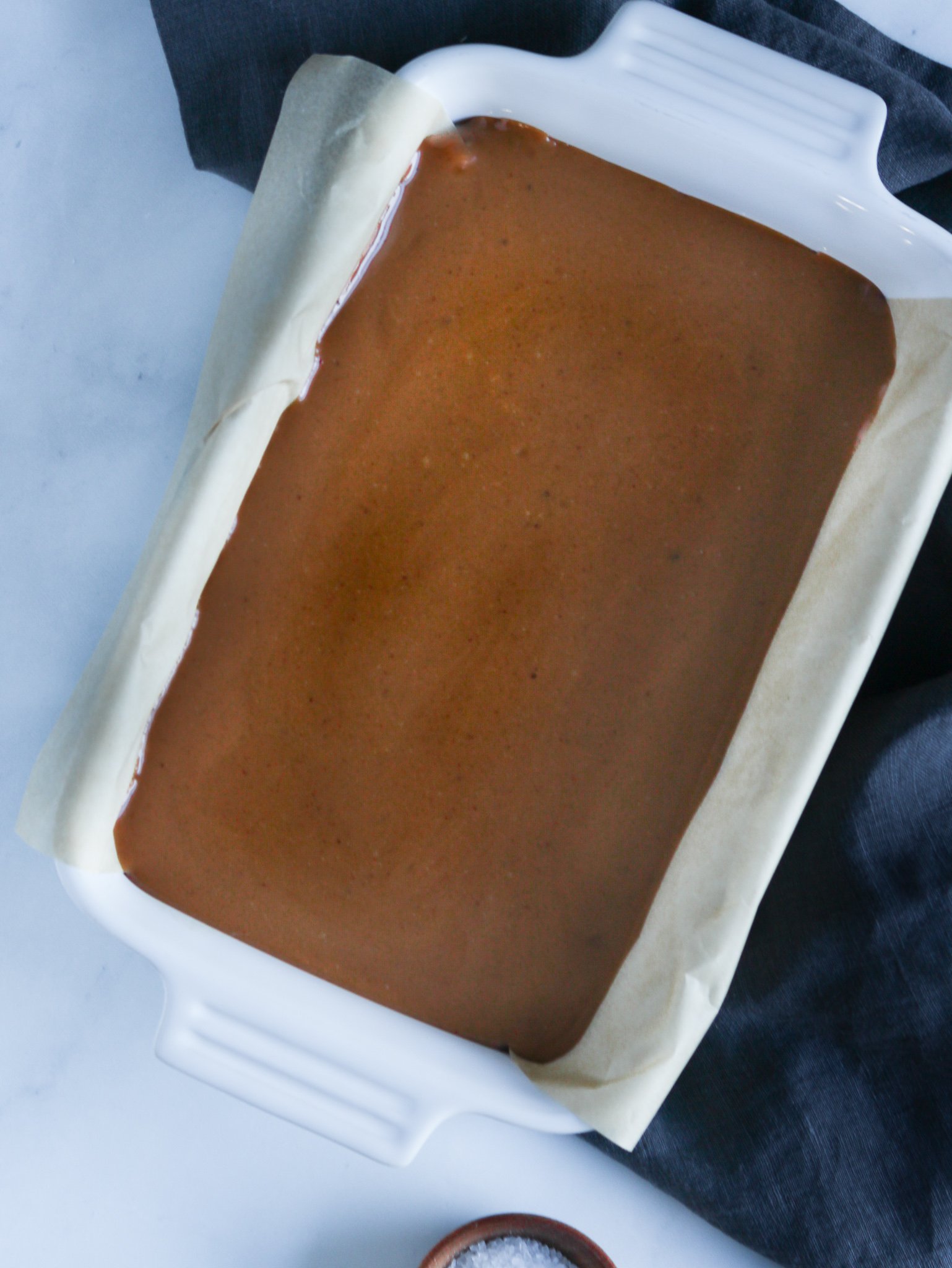 homemade caramel candy cooling in a white baking pan.