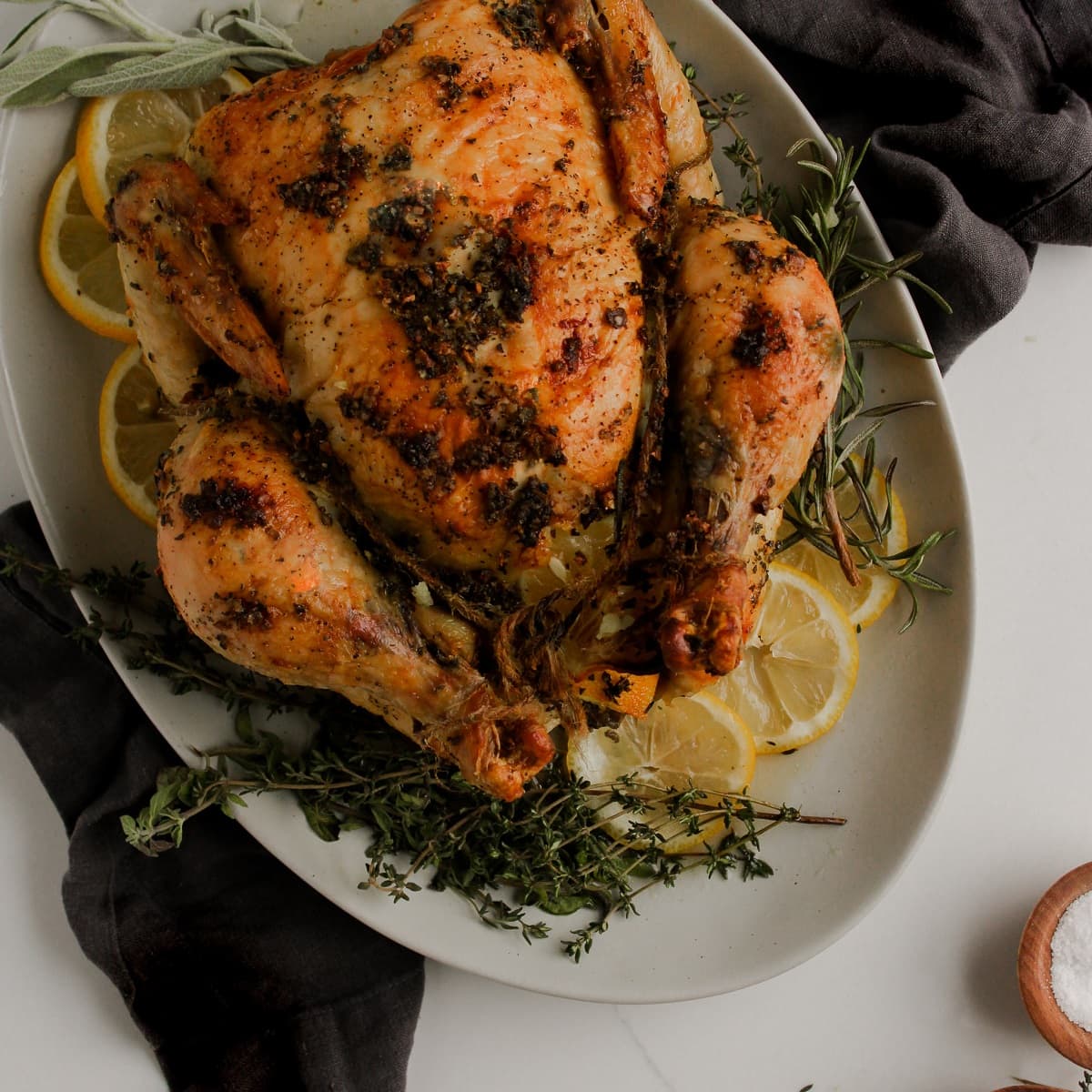 Roasted lemon herb butter turkey on a serving platter ready to be carved and enjoyed on Thanksgiving.